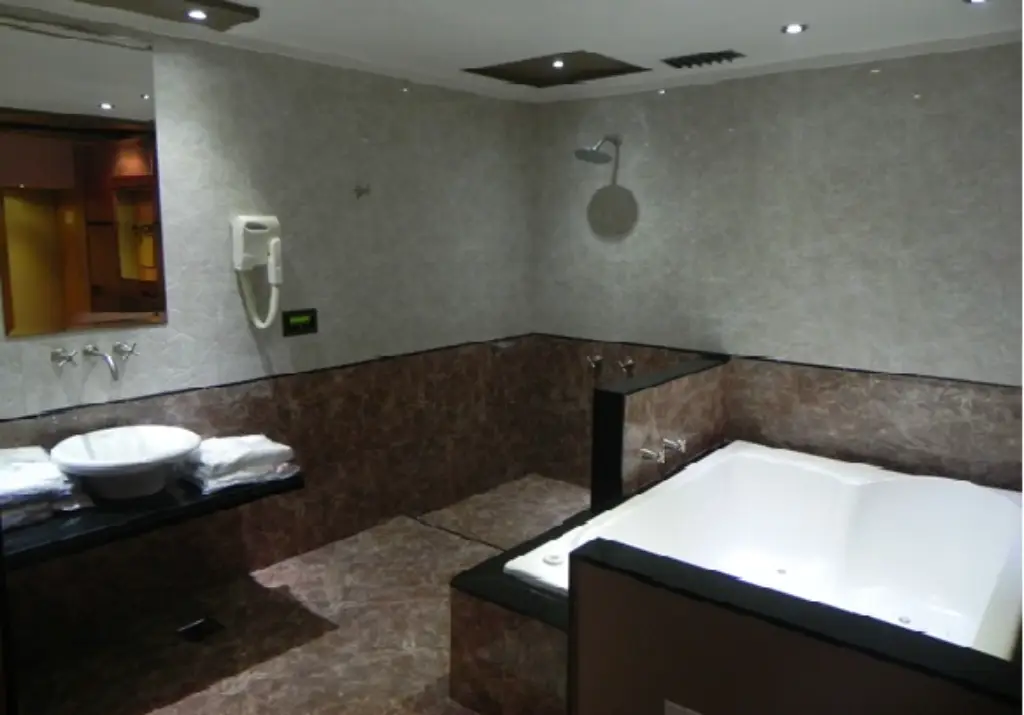 Habitación íntima con luces tenues y cama matrimonial en Hotel Plus