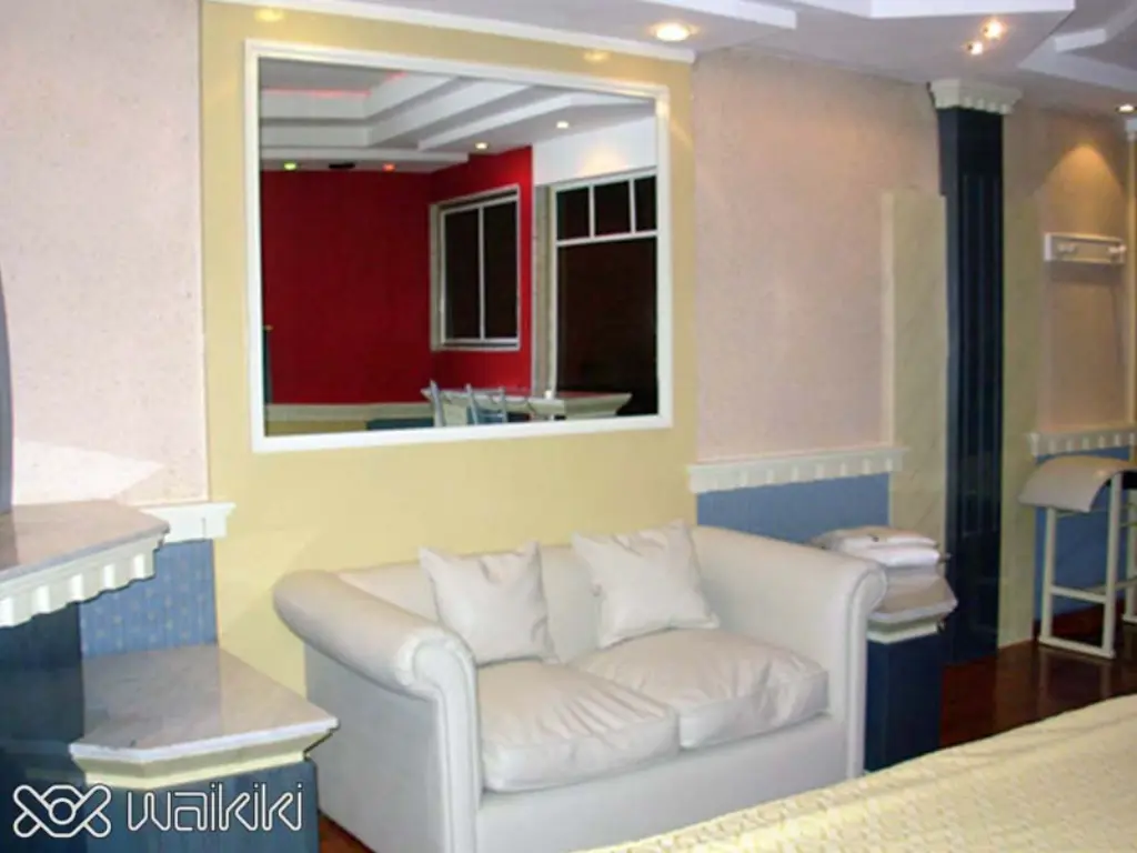 Cama circular con luces rojas en suite Waikiki, Caballito