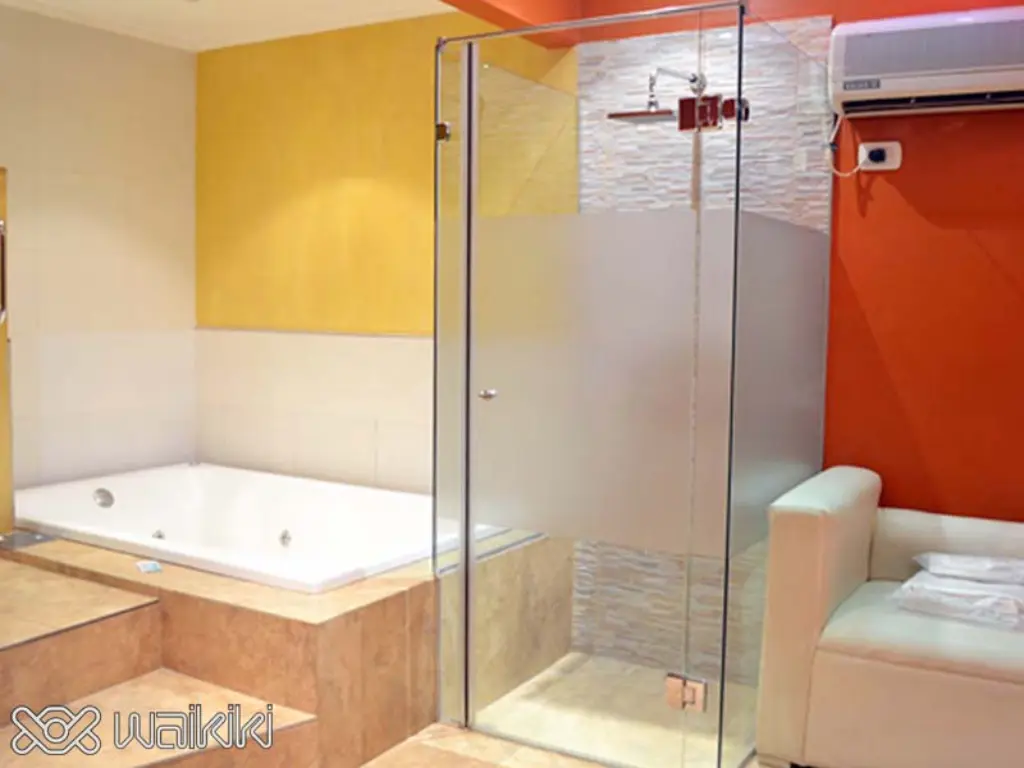 Suite moderna con cama king y luz tenue en Waikiki