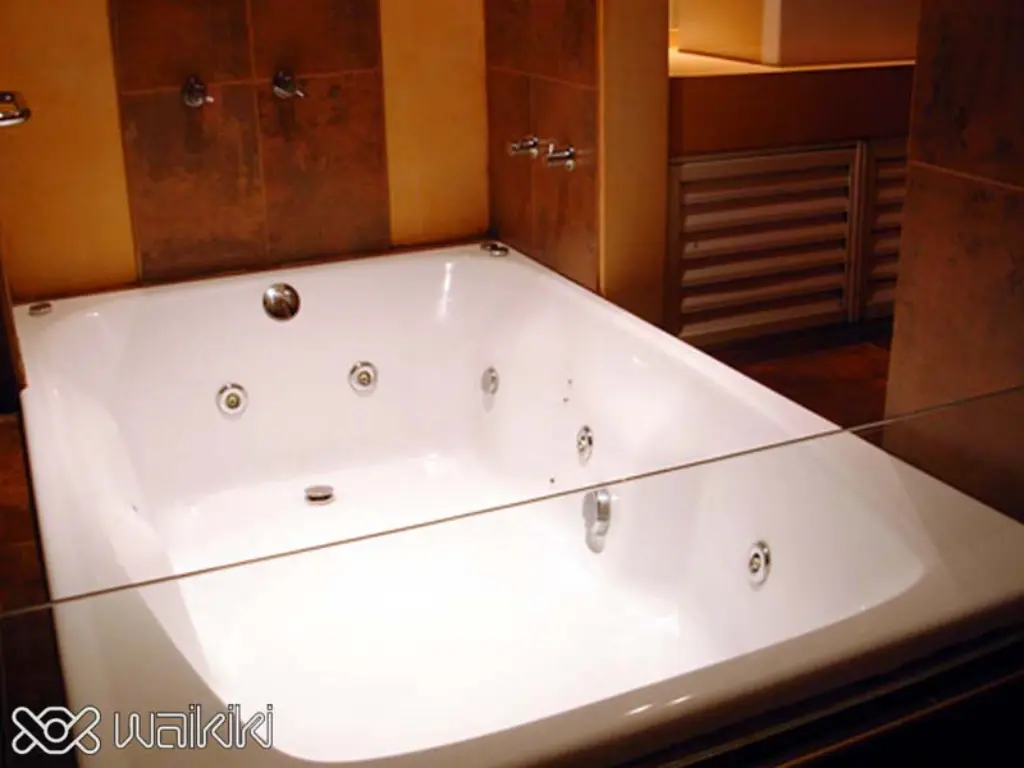 Cama king con espejo en el techo en habitación por horas